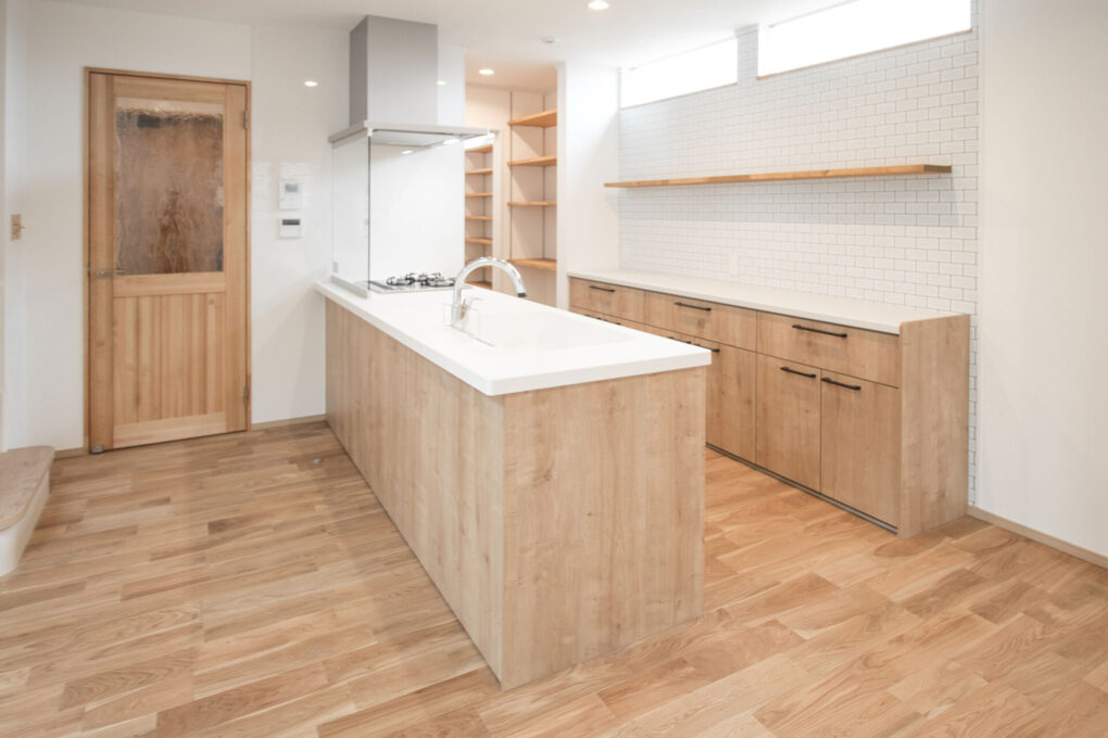 《キッチン》ナチュラルな色合いで統一した無垢材の床や建具、造作のキッチン