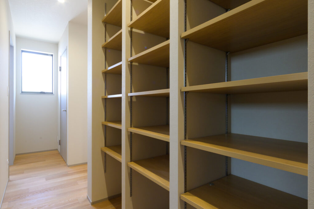 《子供室前収納》子供室にはあえて収納を作らず、廊下に3人分の稼働棚を設置。ご両親が見守りながら学校用品を自分たちで整理整頓できるようにという工夫です。