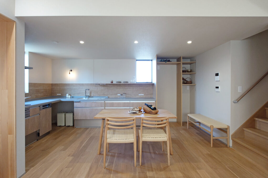 《キッチン》広いL字のキッチン。収納を作りにくいコーナーはあえて扉をつけず、ゴミ箱を置くスペースとしてスッキリ見せています。