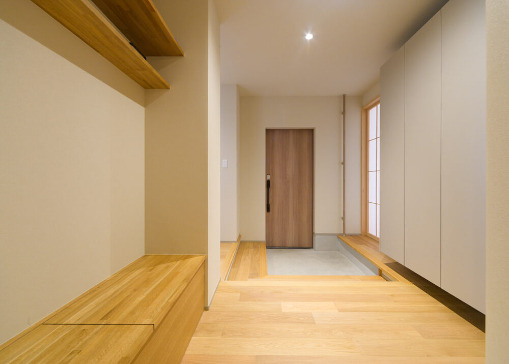 《玄関ホール》広い玄関には大容量の収納も確保。玄関のベンチはお待たせしているお客様に腰掛けてもらうためのもの。