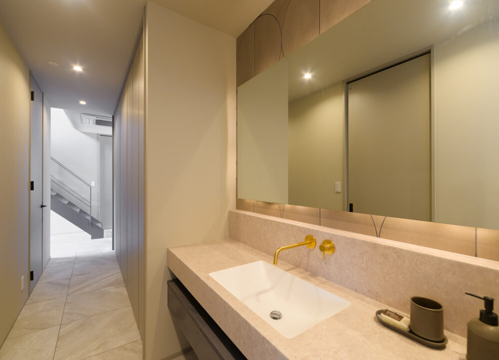 《洗面室》ホテルのような造作洗面台。壁面パネルはキッチンと共通。下の引き出しもこだわりの造作です。