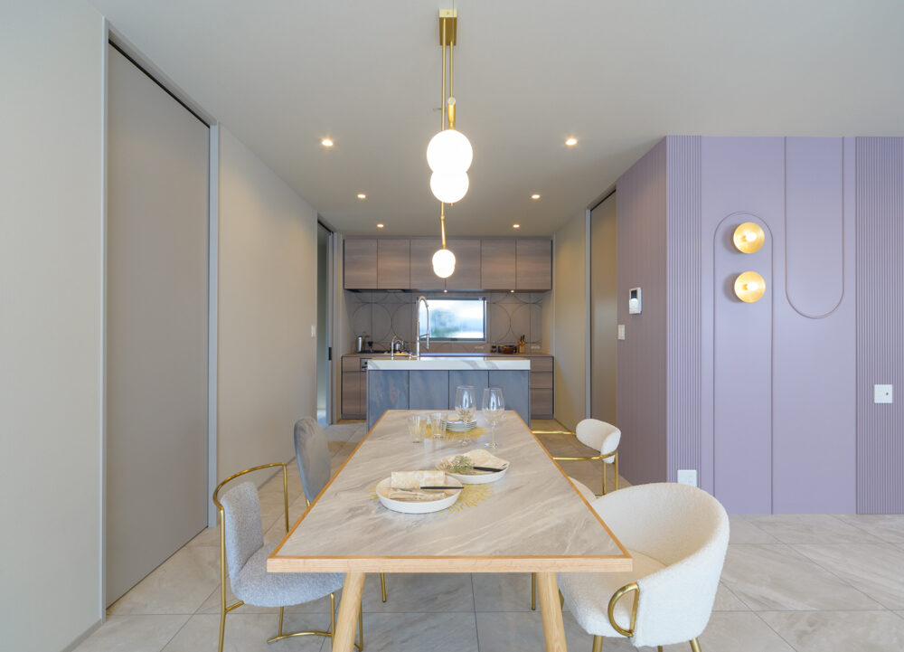 《ダイニング》上品なゴールドのライトがシンプルながらも映えます。淡いパープルの壁は造作でオリジナルの模様を表現。